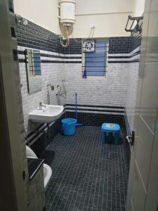a bathroom with a sink and a toilet at Castle JP Deluxe in Bangalore