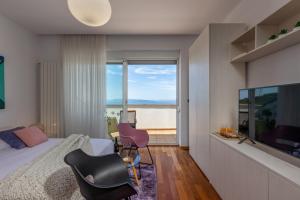a bedroom with a bed and a large window at Terra Magica Deluxe Apartment Or Room with Private Parking, Terrace and Sea View in Rijeka