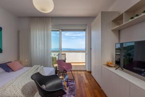 a bedroom with a bed and a large window at Terra Magica Deluxe Apartment & Room with Private Parking, Terrace and Sea View in Rijeka