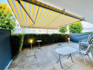 a patio with chairs and a table and awning at Gracehomes in Herrenberg