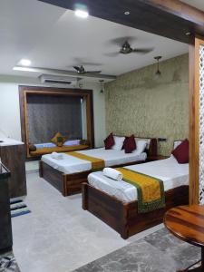 een slaapkamer met 2 bedden en een tafel bij Sakuntala Residency in Bhubaneshwar