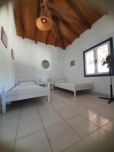 a room with two beds and a ceiling at Stafida Guesthouse - Myrtò in Finikounta
