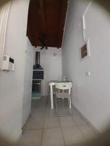 a small white kitchen with a table and a stove at Stafida Guesthouse - Myrtò in Finikounta