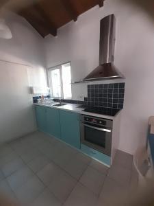 a kitchen with blue cabinets and a stove top oven at Stafida Guesthouse - Myrtò in Finikounta
