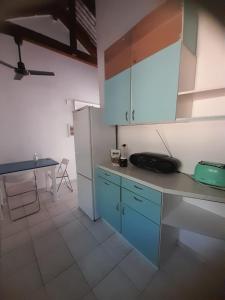 a kitchen with blue cabinets and a table in it at Stafida Guesthouse - Myrtò in Finikounta