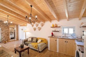 塔維拉的住宿－Quinta do Silêncio T2，厨房以及带沙发和桌子的客厅。