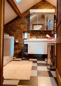 a bathroom with a sink and a mirror at Faire une pause avec le temps in Thimister