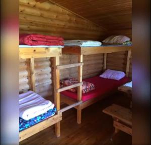 a room with two bunk beds in a log cabin at Lätasenonmajat in Enontekiö