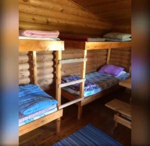 a room with two bunk beds in a log cabin at Lätasenonmajat in Enontekiö