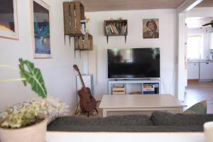 een woonkamer met een bank, een tafel en een tv bij Noah's Ark in Klitmøller