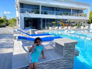 una bambina in piedi accanto alla piscina di Bingo House Watamu, A Modern 5-Bedroom Villa with Pool, A Kids Heaven a Watamu