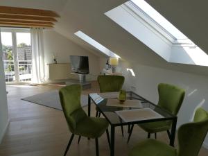 a living room with a table and green chairs at Ferienwohnung Berliner Straße in Schloß Holte-Stukenbrock