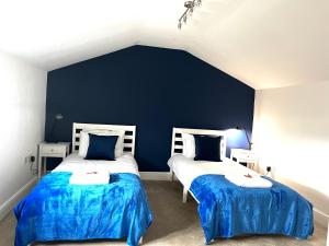 two beds in a room with blue walls at Huge 2 Bedroom 2 Bathroom Apartment - Northgate House in Ipswich