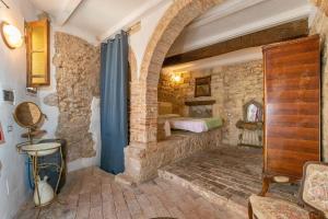 - une chambre avec un lit dans un mur en pierre dans l'établissement Un Pezzo di storia vicino al mare, à Rosignano Marittimo