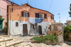 una casa vieja con una sábana azul colgando de ella en Un Pezzo di storia vicino al mare en Rosignano Marittimo