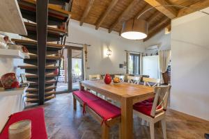uma cozinha e sala de jantar com uma mesa de madeira e cadeiras em La Casa di Valverde em Alghero