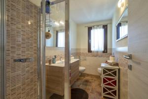 uma casa de banho com um chuveiro, um lavatório e um WC. em La Casa di Valverde em Alghero