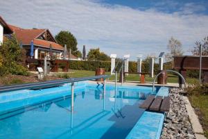 uma piscina com um banco ao lado de uma casa em Feriendorf Öfingen 08 em Bad Dürrheim