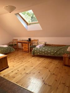 um quarto com 2 camas e uma clarabóia em Ośrodek Wrzosowa Góra - pokoje em Ruciane-Nida