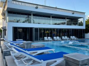 una piscina con sedie a sdraio e un edificio di Bingo House Watamu, A Modern 5-Bedroom Villa with Pool, A Kids Heaven a Watamu