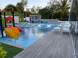 a pool with a slide and a playground at Bingo House Watamu, A Modern 5-Bedroom Villa with Pool, A Kids Heaven in Watamu