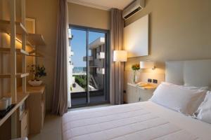 um quarto de hotel com uma cama e uma janela em Hotel Ostuni em Rimini