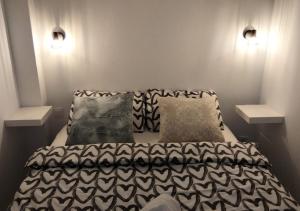- un lit avec des draps et des oreillers en noir et blanc dans l'établissement Exclusives Apartment 10 meters to Ocean, à Maspalomas