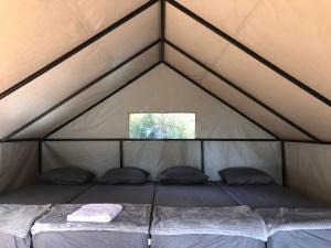 a bed in a tent with a window at Kampung Rimba by Anrha in Bogor