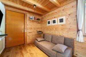 a living room with a couch and a wooden wall at Steinbach Loft in Ultimo