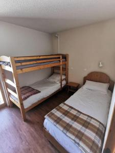 a bedroom with two bunk beds and a ladder at PLAGNE BELLECOTE - 5 Pers - Vue Pistes - Acces Piscine chauffee in Plagne Bellecote