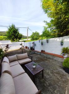 a backyard with a couch and a coffee table at Apartamento Itsasoa Barrika in Barrika