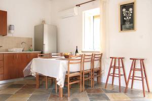 
a kitchen with a table, chairs and a refrigerator at I Plateia in Kalopanayiotis
