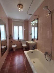 a bathroom with a tub and a toilet and a sink at Apartamento Itsasoa Barrika in Barrika