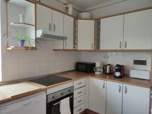 a kitchen with white cabinets and a stove top oven at Apartamento Itsasoa Barrika in Barrika