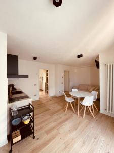 een keuken en een woonkamer met een tafel en stoelen bij Tellure apartments with breakfast in Berbenno di Valtellina