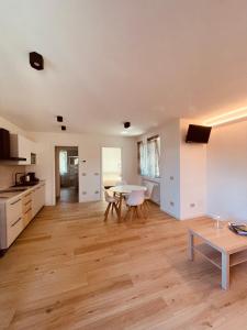 een woonkamer met een tafel en een keuken bij Tellure apartments with breakfast in Berbenno di Valtellina