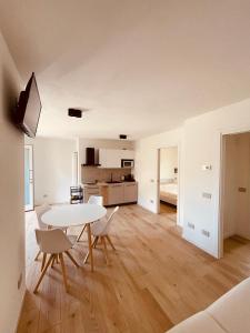 een woonkamer met een witte tafel en stoelen bij Tellure apartments with breakfast in Berbenno di Valtellina