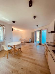een keuken en een woonkamer met een tafel en stoelen bij Tellure apartments with breakfast in Berbenno di Valtellina