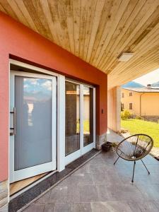 een patio met glazen schuifdeuren en een bank bij Tellure apartments with breakfast in Berbenno di Valtellina