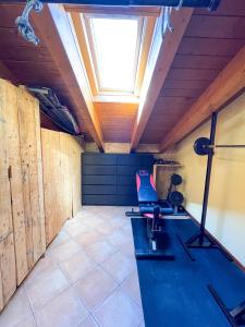 a gym with a chair in a room with a skylight at Appartamento vista colline in Cavola