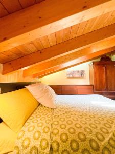 a large bed in a room with wooden ceilings at Appartamento vista colline in Cavola