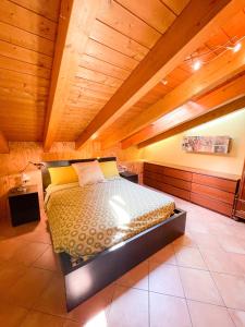 a bed in a room with a wooden ceiling at Appartamento vista colline in Cavola