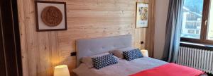 een slaapkamer met een bed met 2 kussens erop bij Appartamento Adalpina in Santo Stefano di Cadore