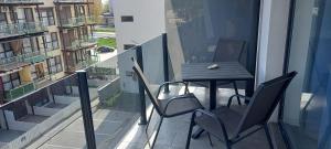 una mesa y sillas en el balcón de un edificio en Garsoniera Saturn en Saturn