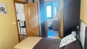 ein kleines Schlafzimmer mit einem Bett und einem Flur in der Unterkunft El Primero G Zaragoza - Aljafería in Saragossa