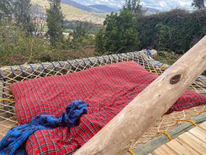 a hammock with a red and blue blanket on it at Hidden Valley Backpackers in Iringa