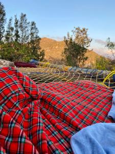 un mucchio di coperte poggiate su una rete di Hidden Valley Backpackers a Iringa