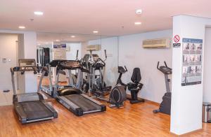 a gym with several treadmills and elliptical machines at Swan Towers in Juffair