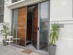 une porte en verre d'un bâtiment avec une plante en pot dans l'établissement Caruma Surf Hostel, à Matosinhos