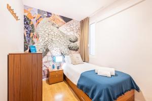 1 dormitorio con 1 cama y un mural en la pared en Sweet Inn - Villarroel, en Barcelona